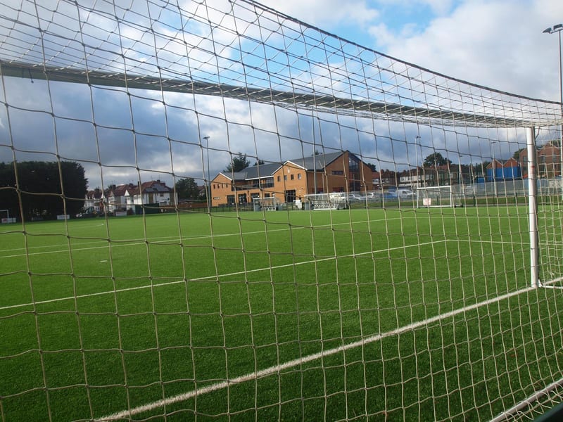 View through the goal net towards the Tithe Farm clubhouse on a match day